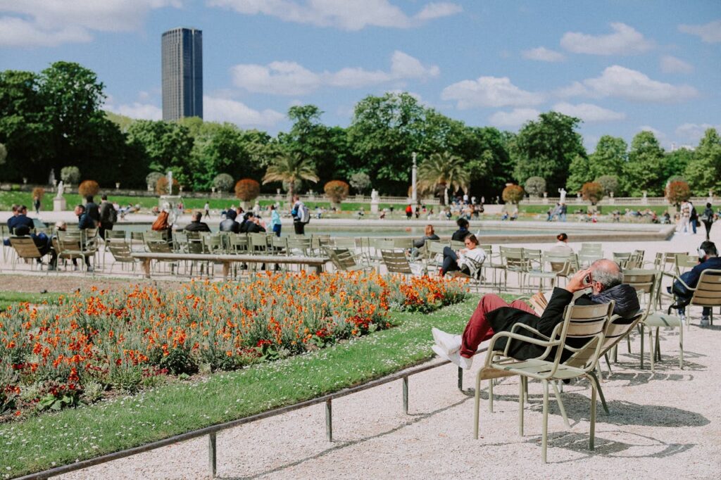 Pessoas tomando sol, lendo no Jardim de Luxemburgo.