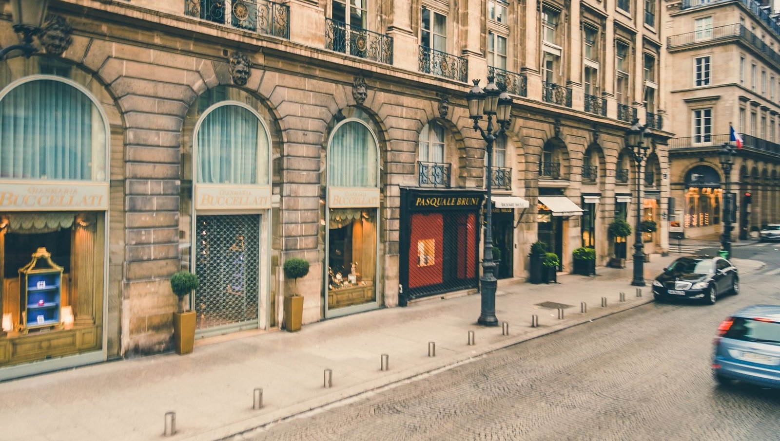 Avenue Montaigne: Roteiro de Compras de Luxo em Paris 2 Vista da Avenue Montaigne com carros e edifícios elegantes em Paris