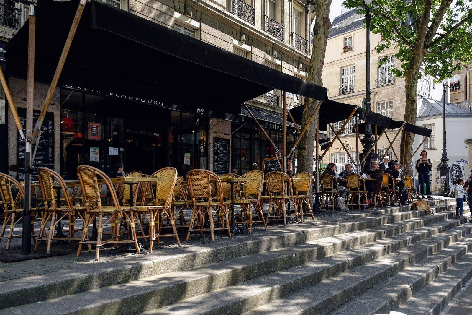 O que Comer em Paris: Guia da Gastronomia Francesa para Brasileiros 2 Terraço de bistrô parisiense com mesas na rua