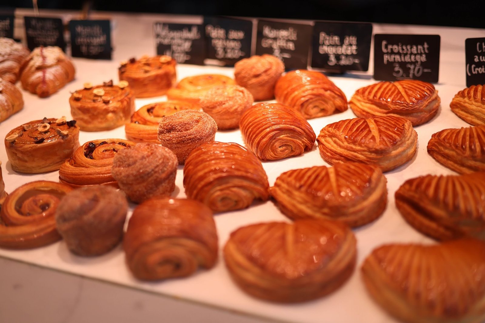 Onde Comer o Melhor Croissant de Paris: Padarias Premiadas 2 Vitrine de croissants e pães em boulangerie francesa em Paris