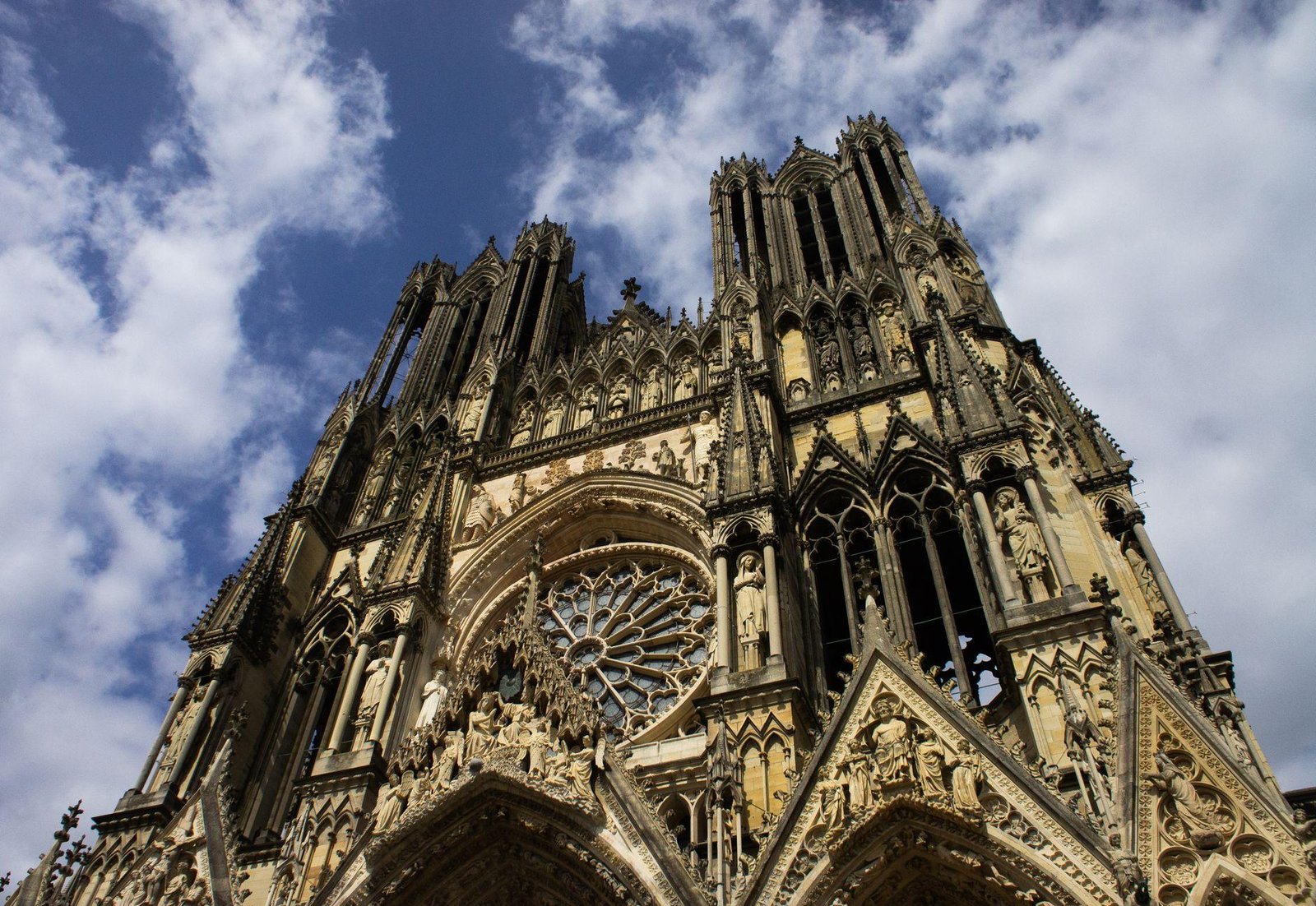 TGV: Viagens de Um Dia Saindo de Paris 2 Fachada gótica da Catedral de Reims vista de baixo contra o céu azul