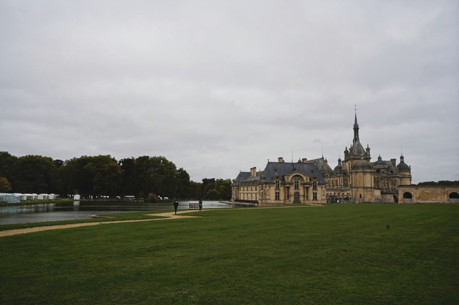 Castelo de Chantilly: Guia Completo do Bate-volta de Paris 2 O Castelo de Chantilly visto de longe cercado de vegetação exuberante