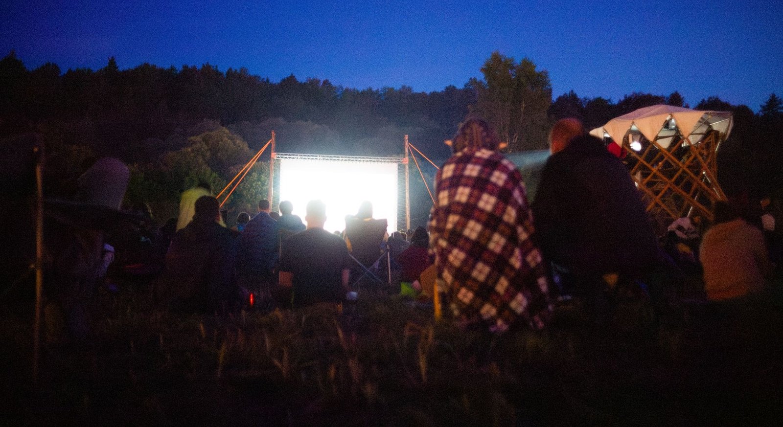 Cinéma en Plein Air 2026 : Cinéma Gratuit en Plein Air au Parc de la Villette (Guide Complet) 1 Adultes réunis en plein air pour une séance de cinéma nocturne sous les étoiles à Paris