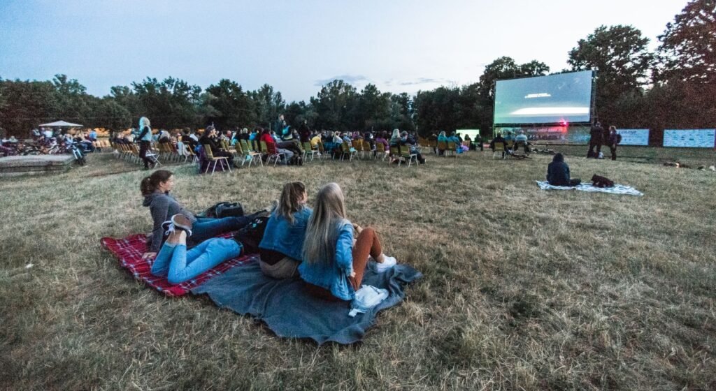Cinéma en Plein Air 2026: Cine Gratuito al Aire Libre en el Parc de la Villette (Guía Completa) 13 Pessoas assistindo cinema ao ar livre à noite em parque de Paris no Cinéma en Plein Air 2026