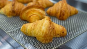 Croissant dourado e folhado em padaria parisiense, Paris
