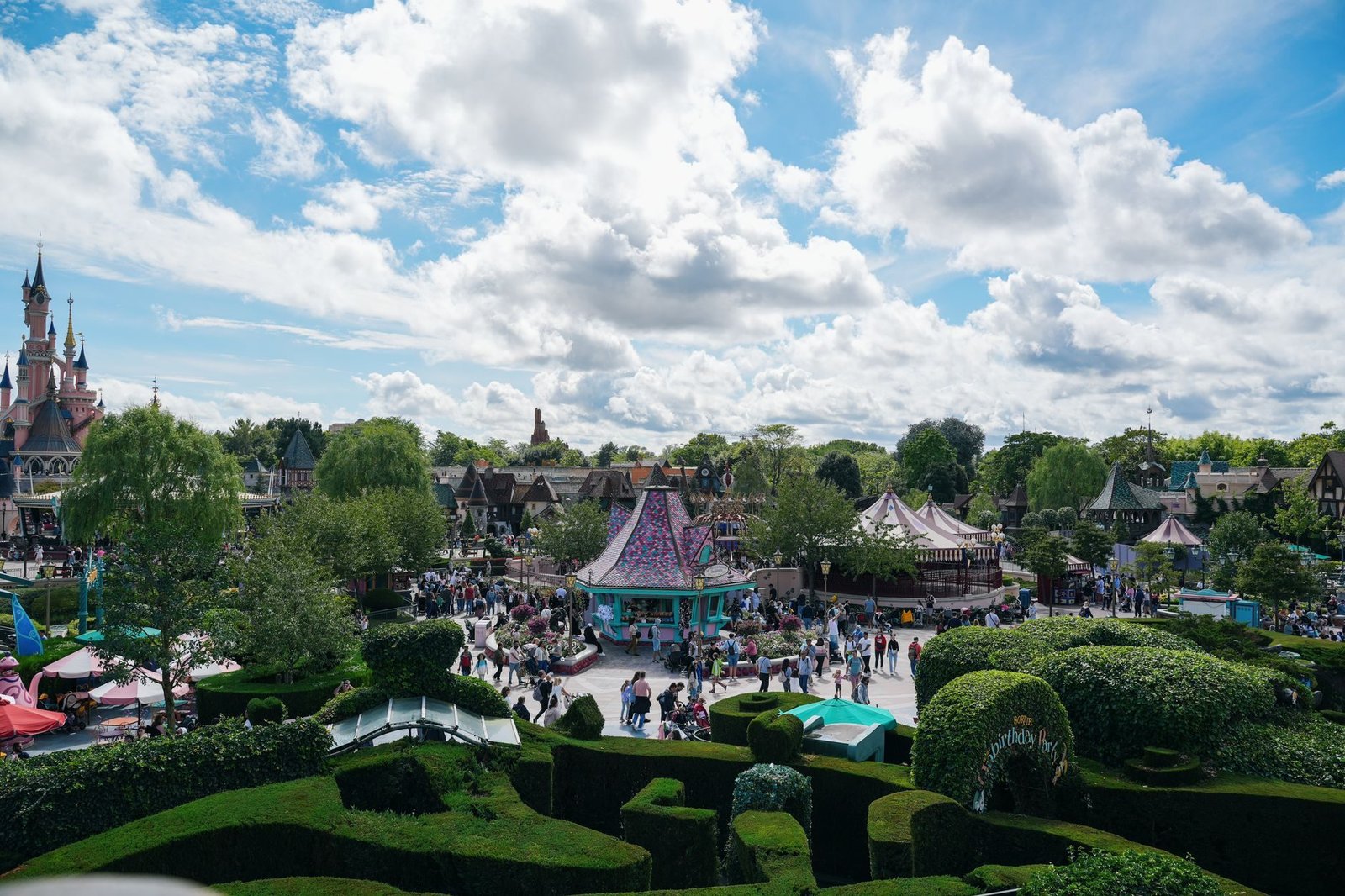 Disneyland Paris ou Parc Astérix: qual escolher? 4 Visitantes aproveitando o dia ensolarado no Disneyland Paris com o castelo ao fundo