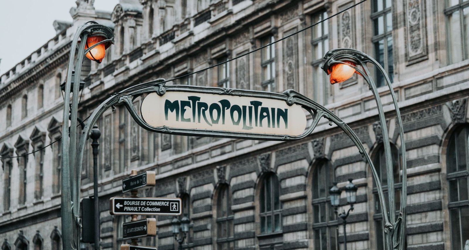 Passe de Transporte em Paris: Navigo, Bilhetes e Preços 2026 1 Entrada de estação de metrô em Paris com letreiro art nouveau verde