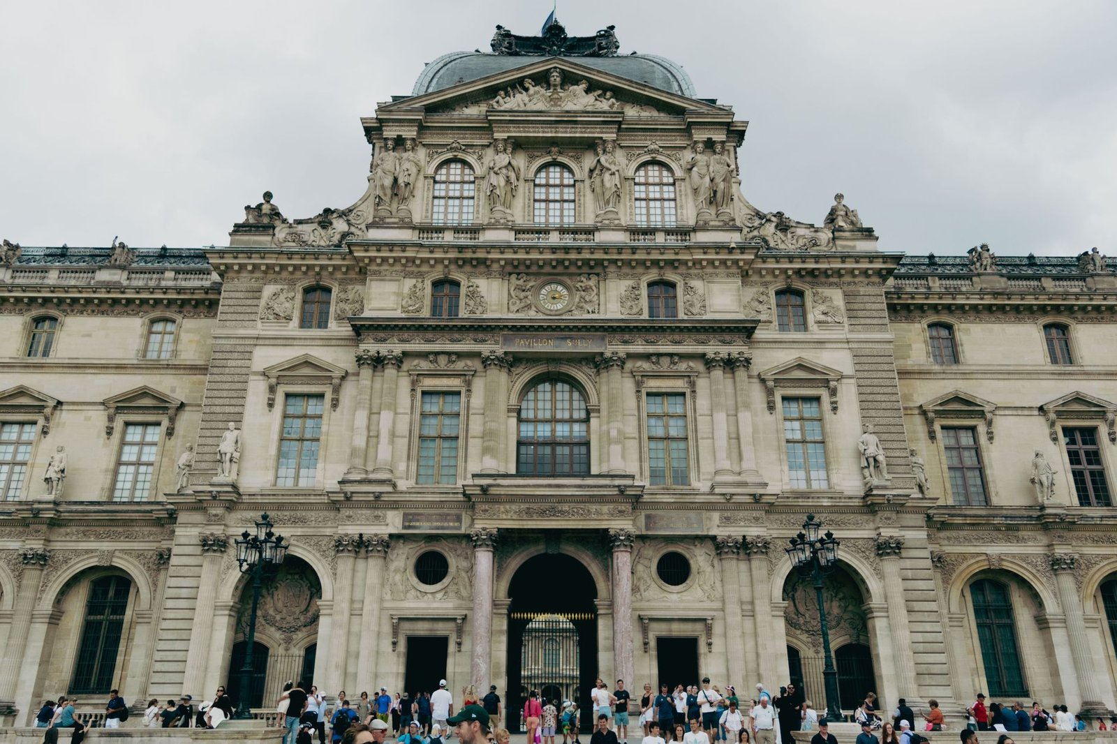 Ingressos do Louvre 2026: Novo Preço para Brasileiros e Como Comprar Sem Pagar Mais Caro 4 Fachada do Museu do Louvre com turistas em Paris