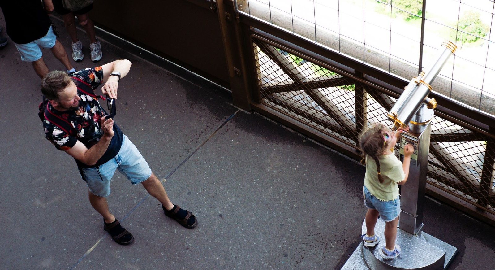 Torre Eiffel com Crianças: Guia Completo para Famílias 1 Pai e filho usando telescópio na Torre Eiffel