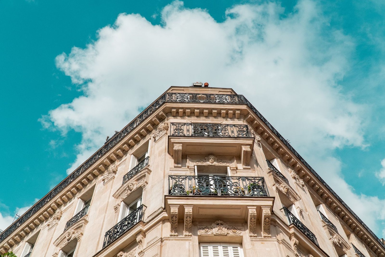 Haussmann e os Boulevards: Por Que Paris Tem Essa Cara 3 Detalhe de sacada e fachada de prédio haussmanniano em Paris