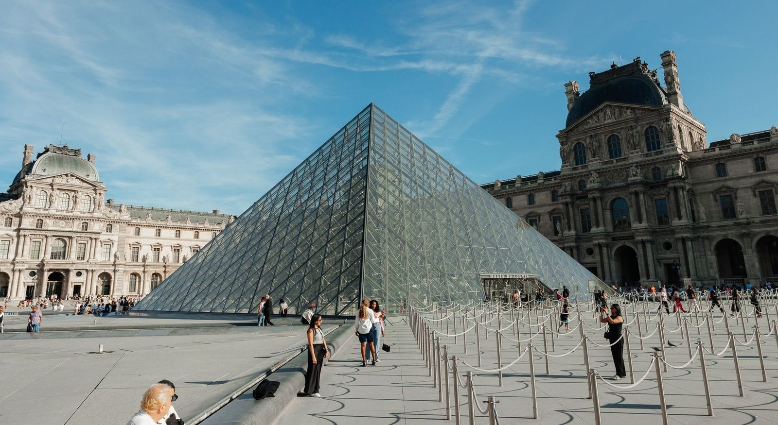 O Que Ver no Louvre em 2 Horas: Roteiro dos Destaques Sem Se Perder 1 Turistas visitando a Pirâmide do Louvre em Paris