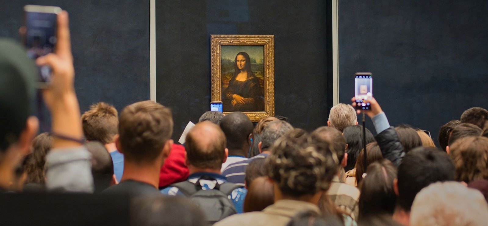 Como Encontrar a Mona Lisa no Louvre (e o Que Ninguém Te Conta Sobre Ela) 1 Multidão de turistas fotografando a Mona Lisa no Louvre