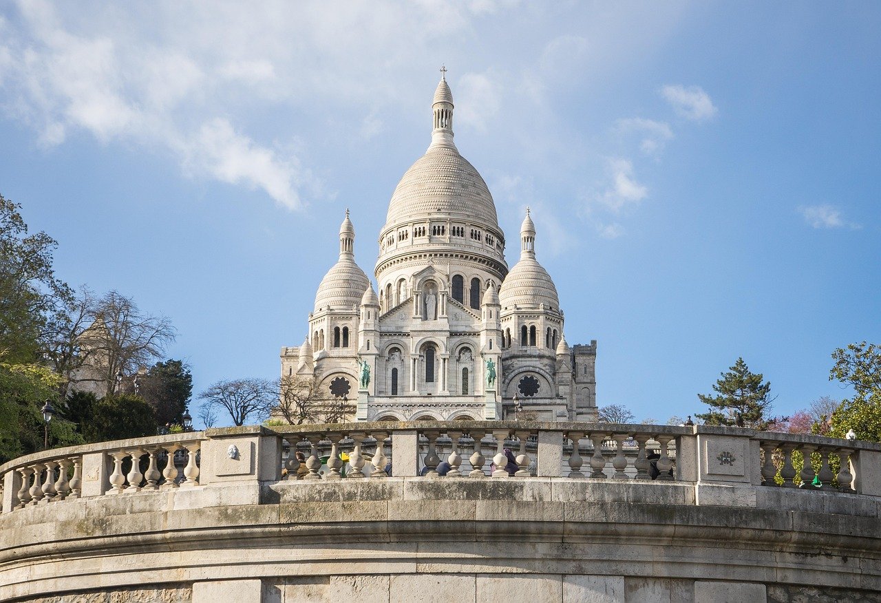 Moulin Rouge em Paris: Vale a Pena? Preços, Ingressos e Dicas do Show 4 Vista noturna de Montmartre em Paris com luzes da cidade ao fundo