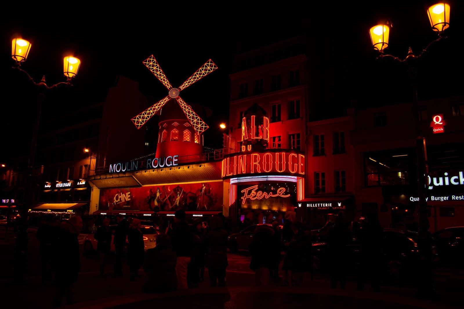 Moulin Rouge: Vale a Pena Assistir ao Show de Cabaré? 2 Boulevard de Clichy à noite com letreiros e vida noturna de Paris