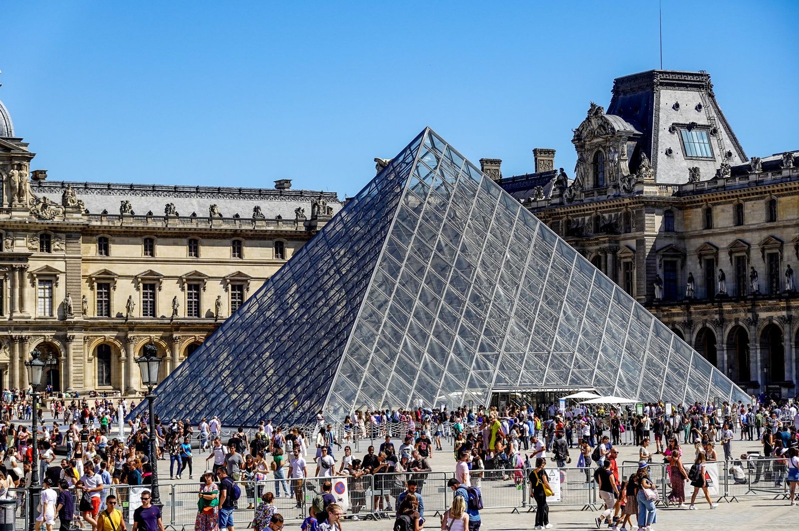 Ingressos do Louvre 2026: Novo Preço para Brasileiros e Como Comprar Sem Pagar Mais Caro 2 Multidão de turistas na Pirâmide do Louvre