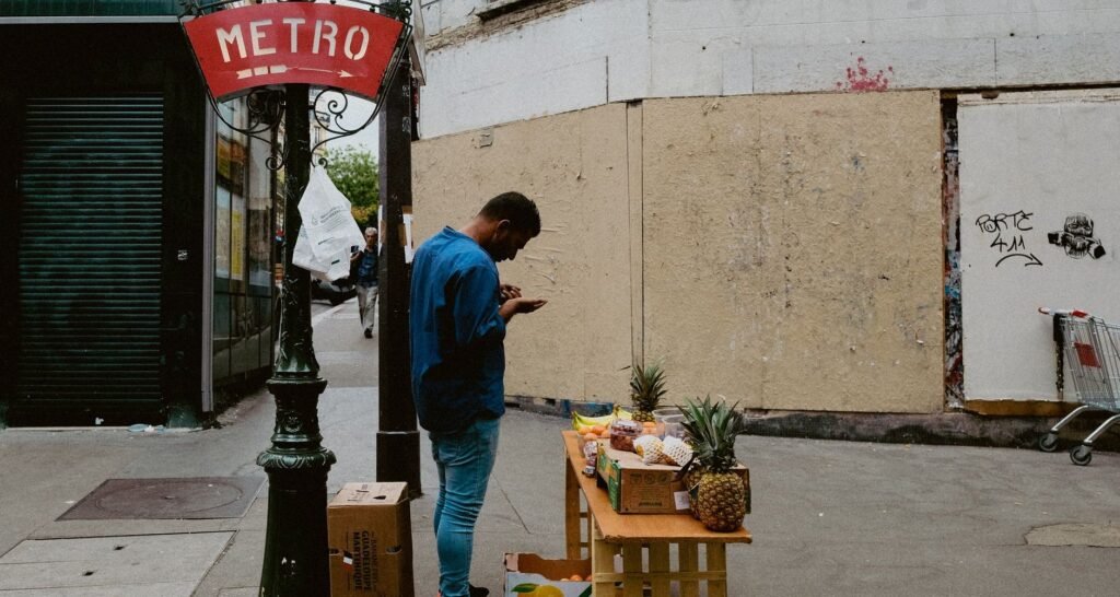 Mercados y Ferias Callejeras en París: dónde ir 19 Vendedor de frutas em barraca de rua próxima ao sinal do Metrô de Paris