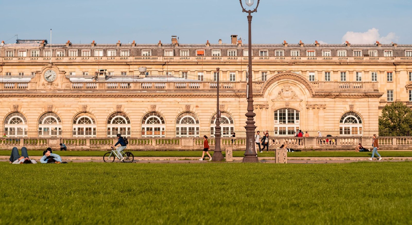Cinéma en Plein Air 2026 : Cinéma Gratuit en Plein Air au Parc de la Villette (Guide Complet) 2 Personnes profitant de l'été près d'un bâtiment historique à Paris en été