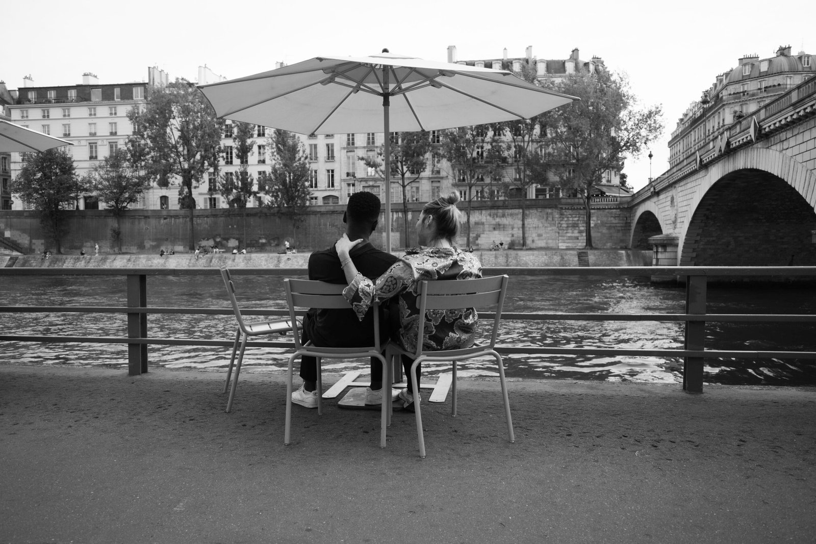 Paris Plages 2026: A Praia Urbana que Toma Conta do Sena no Verão 2 Casal descansando à beira do Rio Sena em Paris Plages