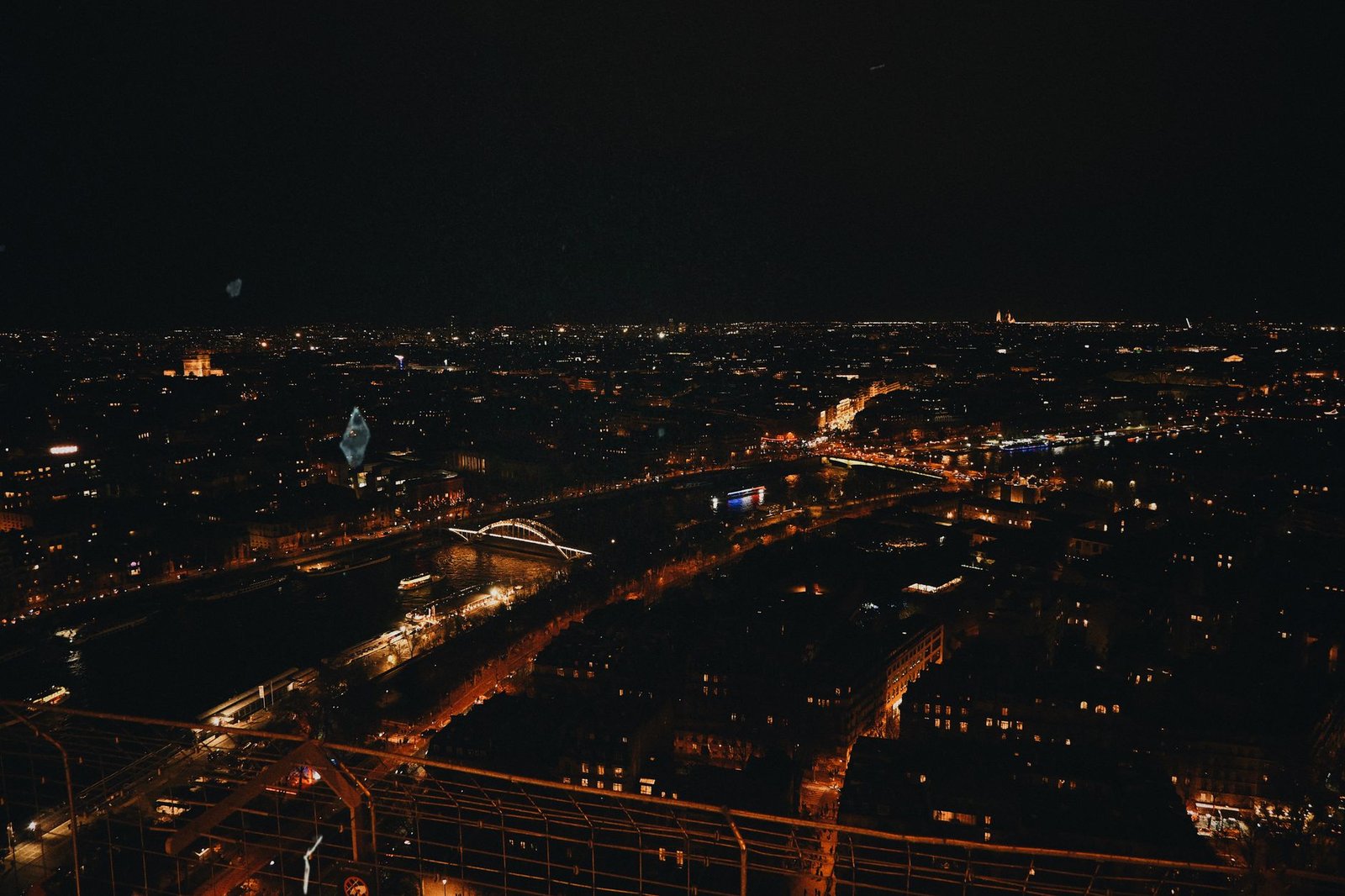 Torre Eiffel a Noite: Show de Luzes, Horarios e Como Ver de Graca 2 Vista noturna de Paris com a Torre Eiffel iluminada ao fundo, capturada de perto