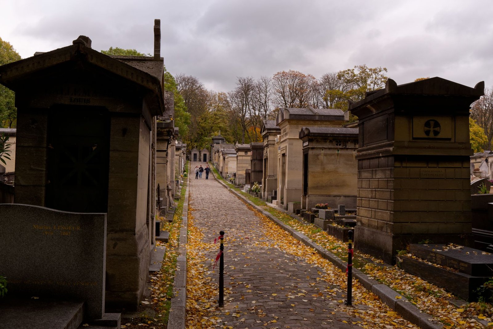 Cemitério Père Lachaise: o roteiro mais inesperado (e fascinante) de Paris 2 Caminho histórico cercado de árvores no cemitério Père Lachaise