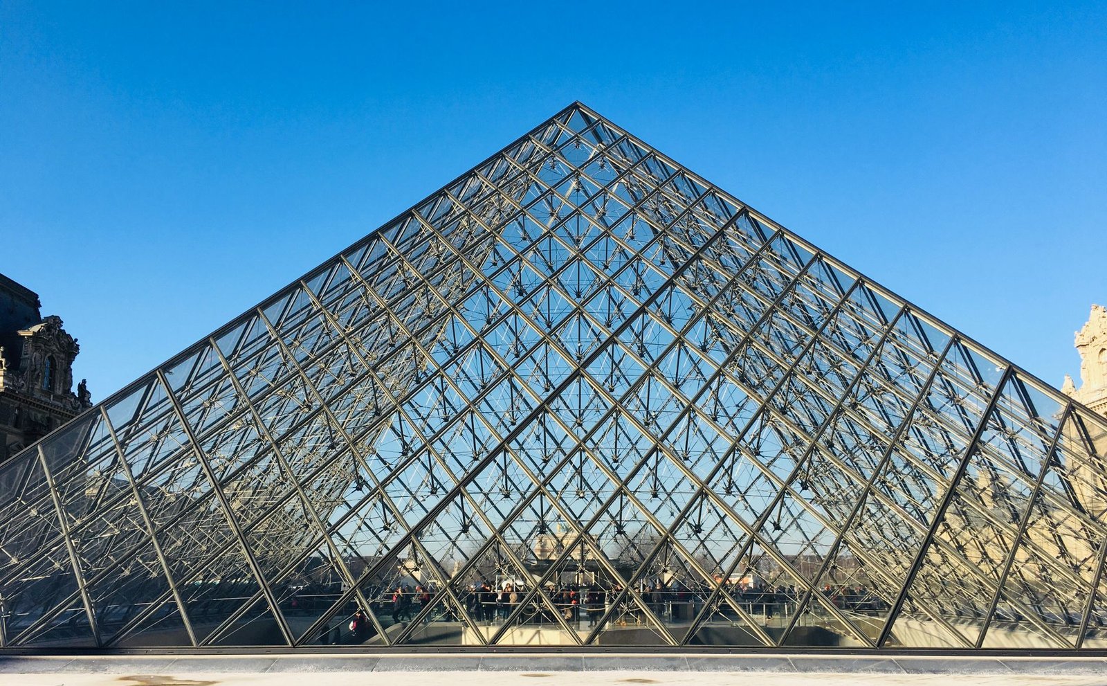 O Que Ver no Louvre em 2 Horas: Roteiro dos Destaques Sem Se Perder 4 Pirâmide de vidro do Louvre com céu azul