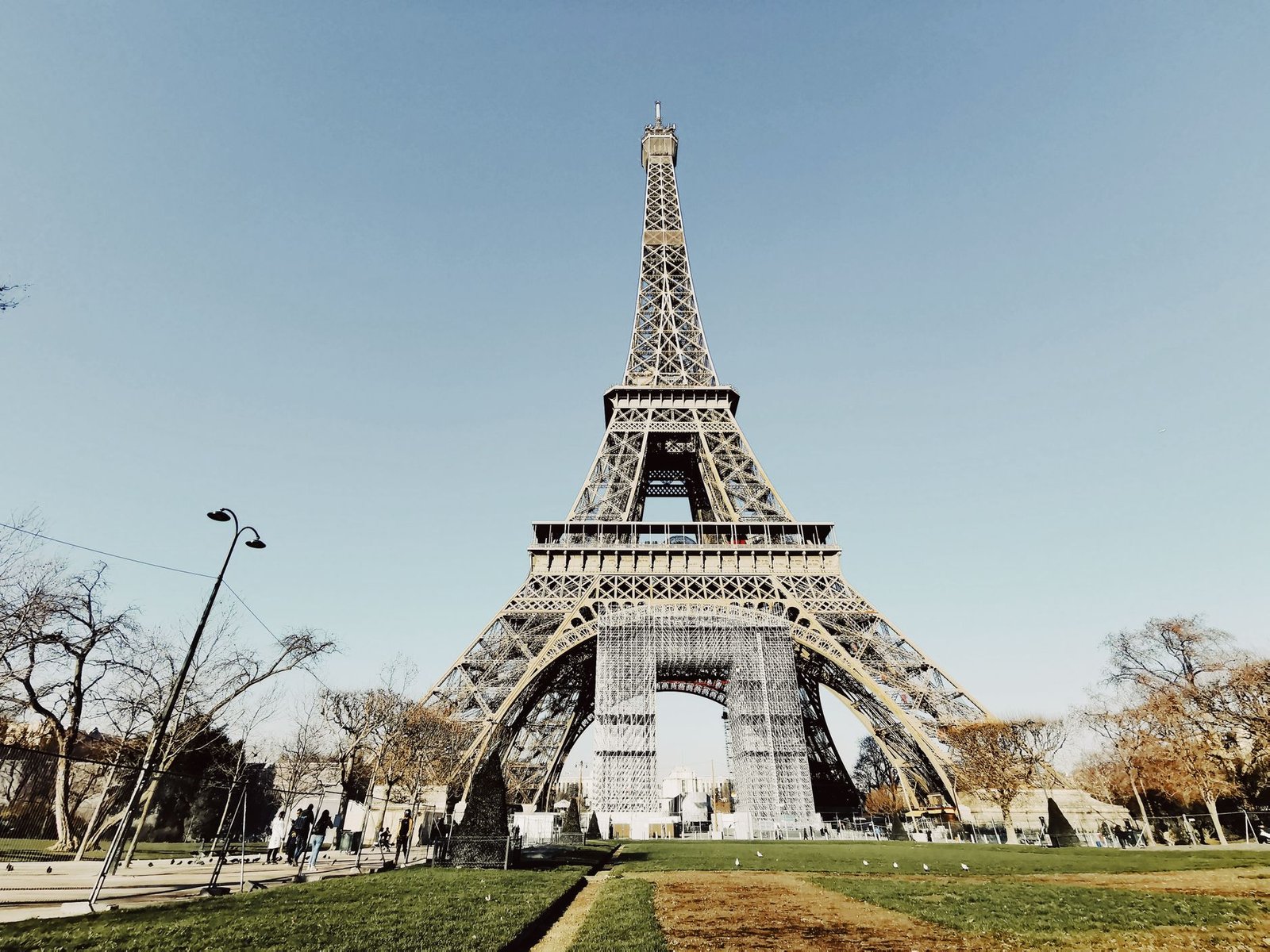 Torre Eiffel com Crianças: Guia Completo para Famílias 3 Vista da Torre Eiffel de baixo com céu azul
