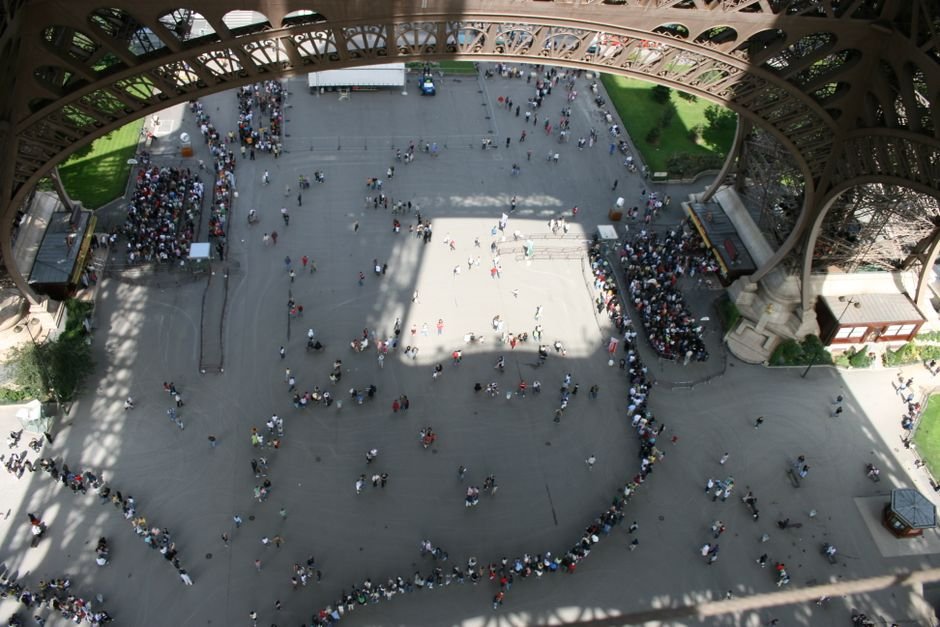 HOME 1 Fila de turistas vista de cima na base da Torre Eiffel