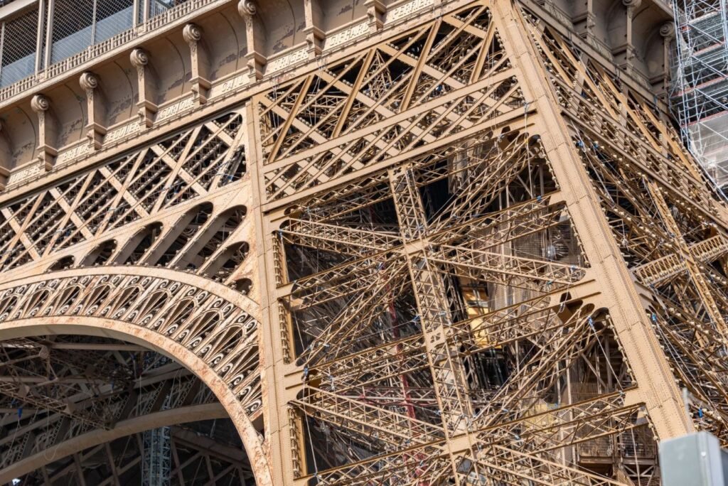 Entradas para la Torre Eiffel: Escaleras vs. Ascensor, Precios y Dónde Comprar 11 Estrutura metálica da Torre Eiffel vista de baixo