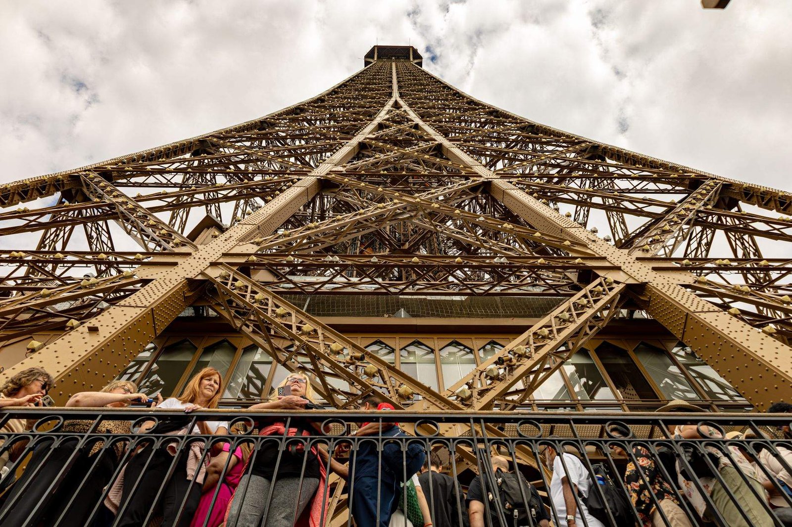 Cómo Evitar la Cola en la Torre Eiffel: Guía Completa Anti-Colas 4 Turistas reunidos en la base de la Torre Eiffel en París