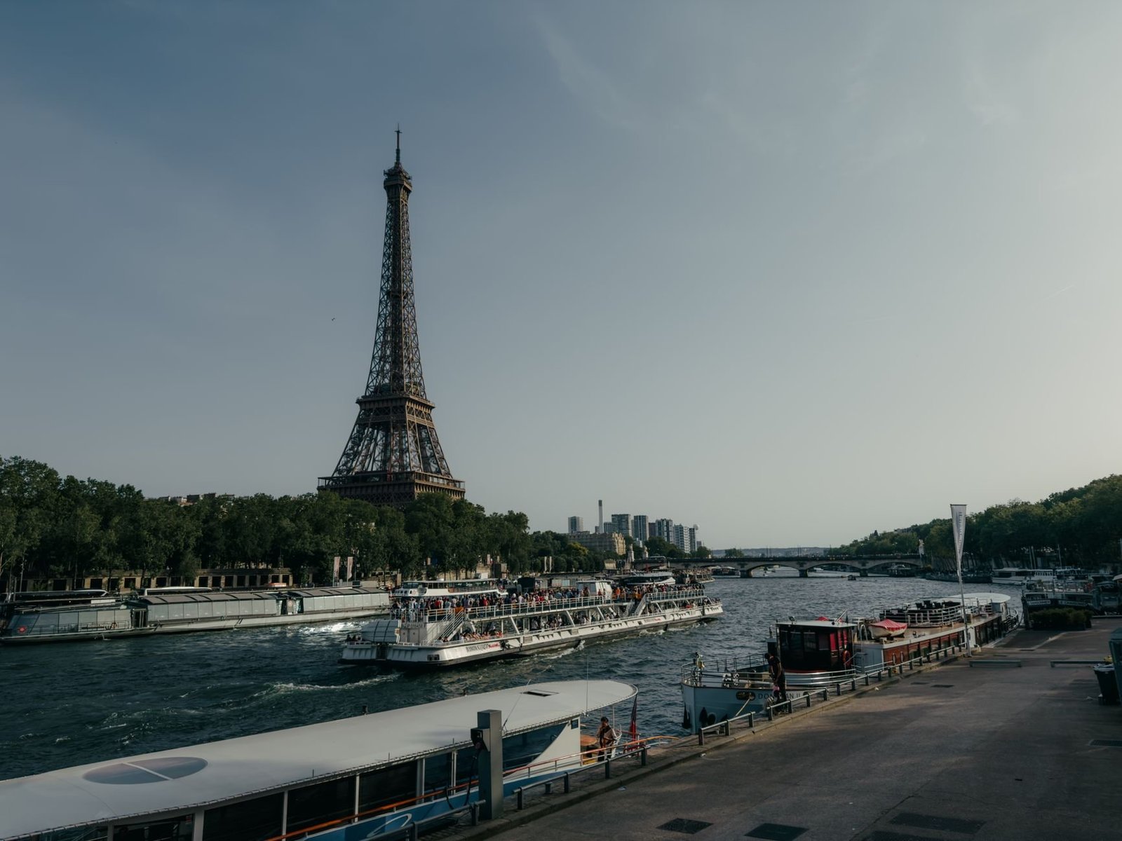 Passeio de Barco no Sena: Vale a Pena Fazer? 2 Vista da Torre Eiffel a partir do Rio Sena com barcos de turismo passando