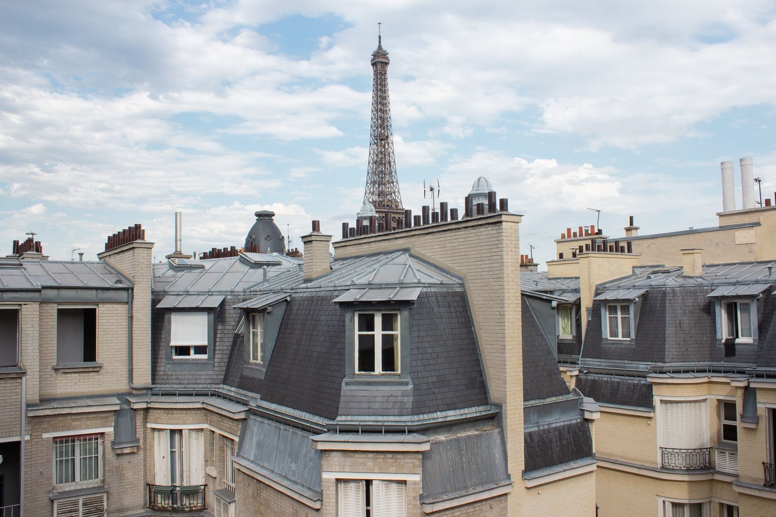 Onde se Hospedar em Paris: Guia por Bairro para Turistas 2 Vista de telhados de Paris com a Torre Eiffel ao fundo, vista de apartamento no 7º arrondissement