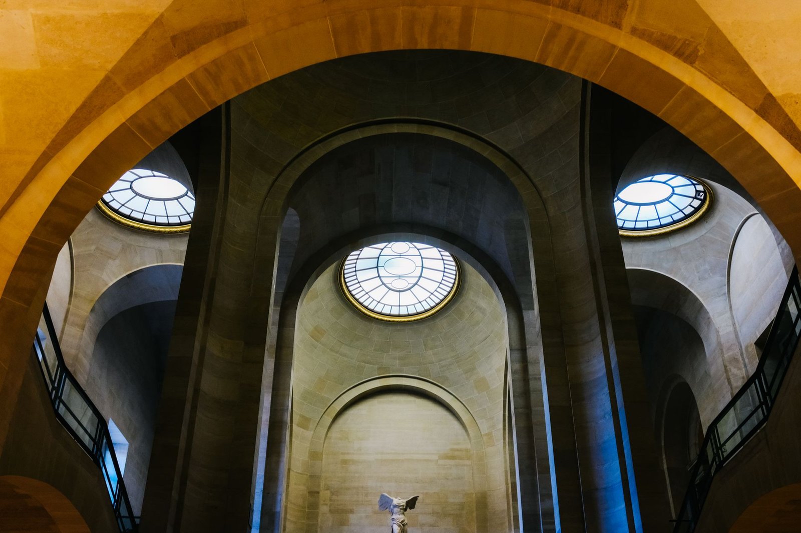O Que Ver no Louvre em 2 Horas: Roteiro dos Destaques Sem Se Perder 2 Vitória Alada de Samotrácia no Louvre com arquitetura ao fundo