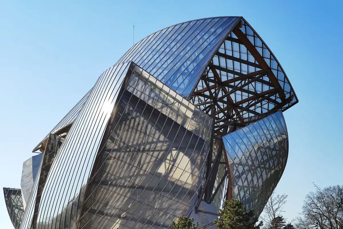 Fondation Louis Vuitton: ingresso, acesso e o que ver 2 Fachada de vidro e aço da Fondation Louis Vuitton sob céu azul em Paris